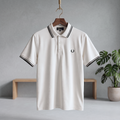 Ecru polo shirt with black striped collar and cuffs, button placket, small chest logo