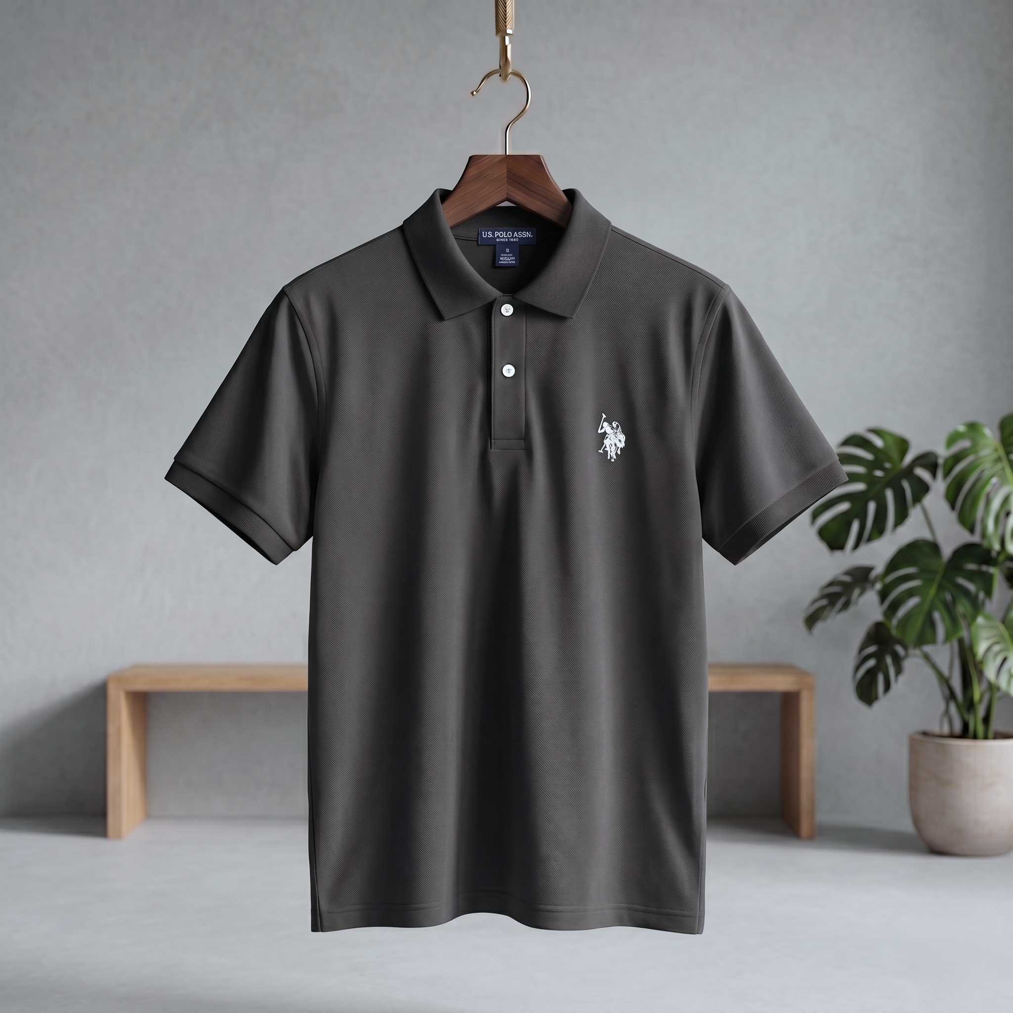 Dark charcoal polo T-shirt with short sleeves, button placket, and small chest logo
