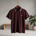 Bordeaux polo shirt with white striped collar and cuffs, button placket, small chest logo