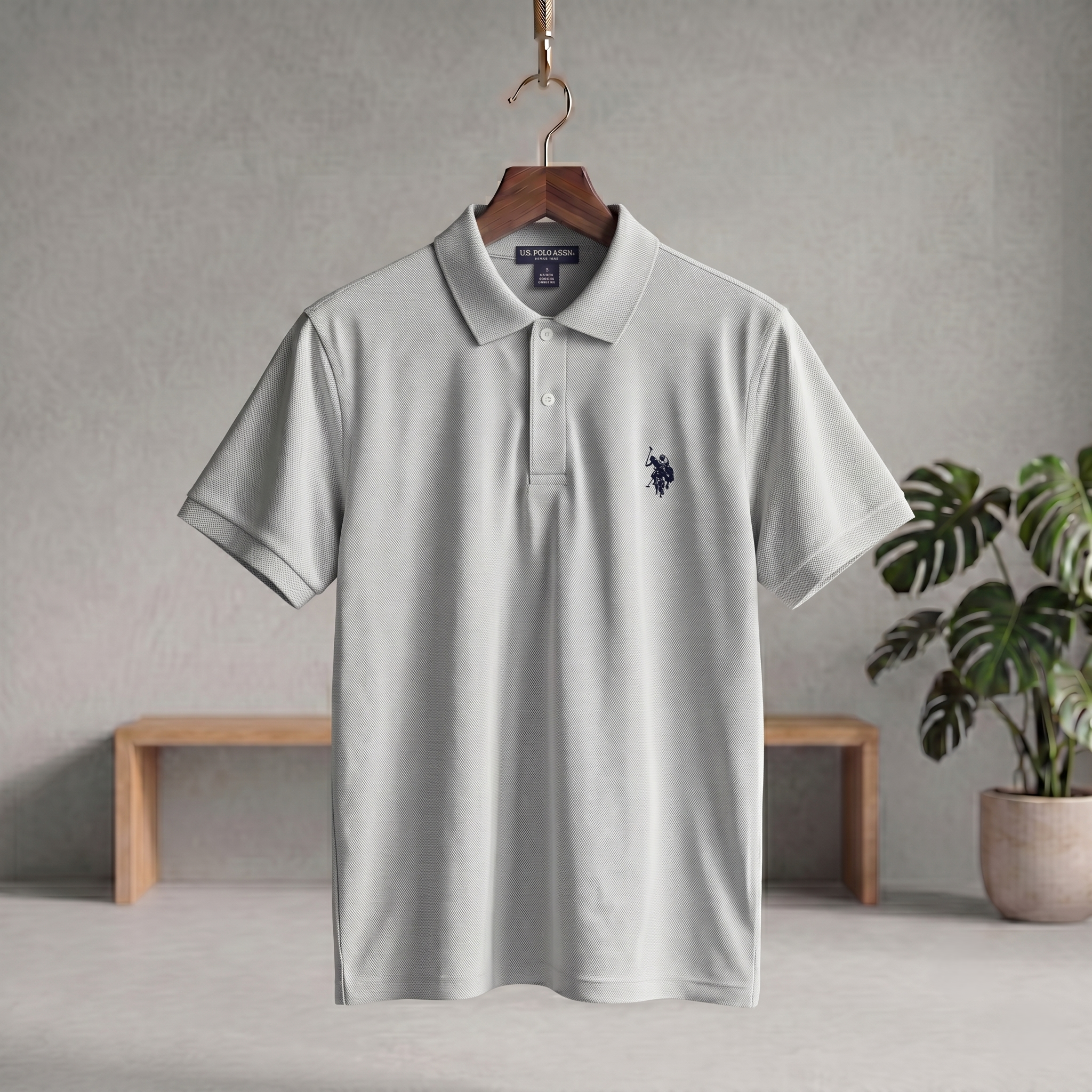Ash polo T-shirt with short sleeves, button placket, and small embroidered logo