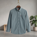 Dark Grey-Green checkered shirt on a hanger against a neutral background with a plant.
